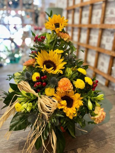 Sunflower Harvest - A stunning front-facing oasis arrangement featuring a vibrant mix of fresh seasonal blooms in warm golden, orange and rich green tones.