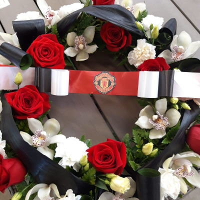 Wreath Ring funeral red roses spray pillow cushion coffin spray - A wreath ring designed in Manchester United's colors.  The circular shape comforts grieving families by representing unbroken unity, since a circle has no start or finish.