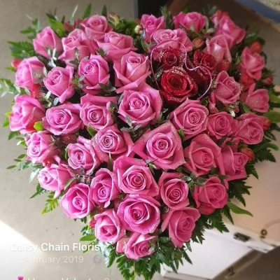 Heart Tribute pink roses coffin spray wreath posy pillow - This beautiful pink rose heart symbolizes an unbreakable bond with a loved one. A solid heart of pink roses, densely packed throughout, represents wholeness, completeness, and love