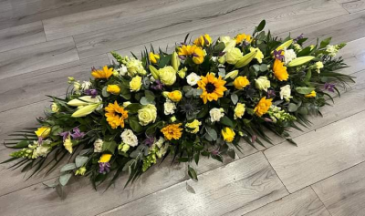 Sunflower Coffin Spray - Sunflowers are always a popular choice, conveying warmth and brightness while celebrating a loved one's life.  With fragrant foliage that complements the overall design.
